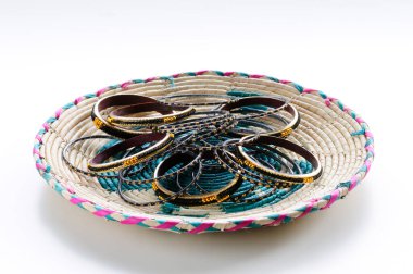 Hasır bir tabakta çeşitli lüks bilezikler.