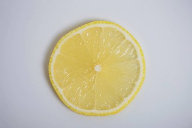 Beyaz arkaplanda taze limon diliminin yakın plan görüntüsü 