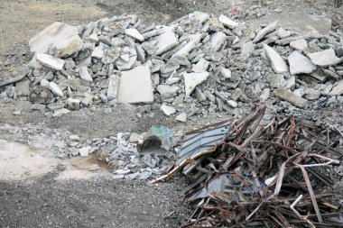 İnşaat alanında dökülen beton molozlar ve bükülmüş metal kalıntıları.