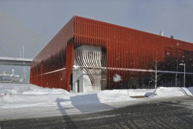 Kışın karla çevrili modern kırmızı bina.