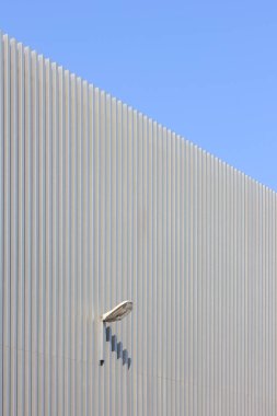 Şehirde büyük beyaz duvarı olan modern bir bina.