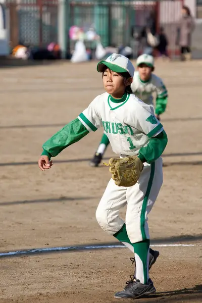 Japanese boy playing baseball on field