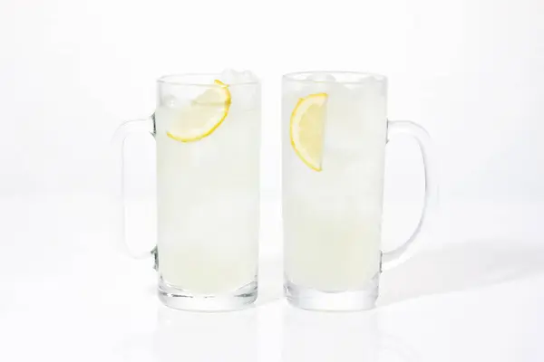 白い背景に隔離されたガラス マグカップの新鮮なレモンスライス — ストック写真