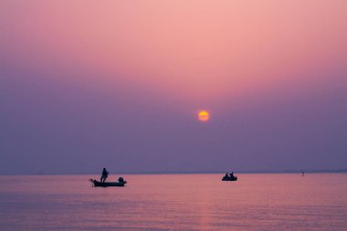 İki tekneyle denizin üzerinde güzel bir gün batımı. 