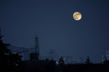 Karanlık gökyüzünde gece şehir ve ayın manzarası