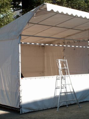 Kurulum sürecinde metal merdiven içeren beyaz açık hava çadırı