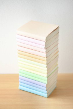 Ahşap masadaki renkli kapaklarda yığınla kitap.