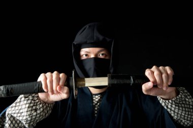 Sırtında katana olan geleneksel giysili genç Asyalı adam. 