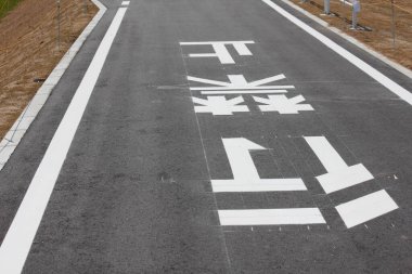 Beyaz asfalt üzerinde yol işaretleri