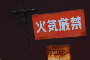 Kapıda Japon karakterleri gösteren kırmızı uyarı işareti