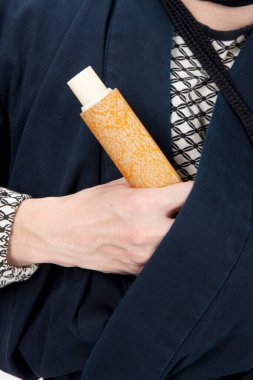 Ninja kostümlü bir adam elinde büyük bir kağıt parçası tutuyor.