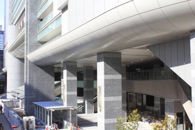 Geniş sütunları ve cam pencereleri olan modern ticari bina dış yüzeyi