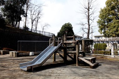 Ağaçlarla çevrili açık hava ahşap oyun alanı