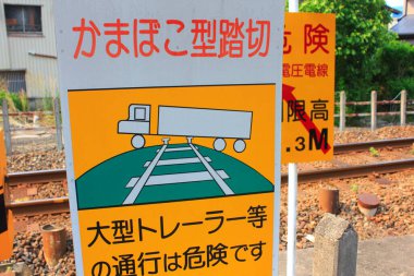 Uyarı levhası, tren raylarının yanında tehlike arz ediyor.