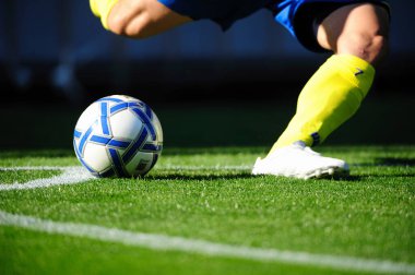 Genç erkek futbolcu sahada top oynuyor.