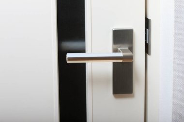 Arka planda modern bir kapı kolu var, kapatın.