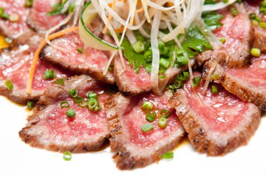 Mutfak masasında dilimlenmiş et tabağı, yakın görüş.