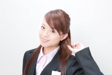 Beyaz arka planda poz veren güzel Japon kadın resepsiyonistin stüdyo portresi