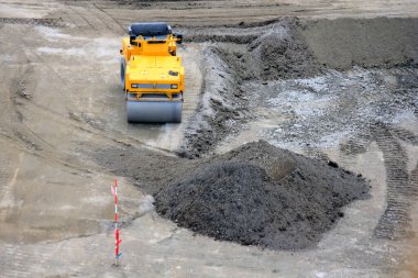 Bir inşaat aracı toprak yığınının içinden geçiyor.