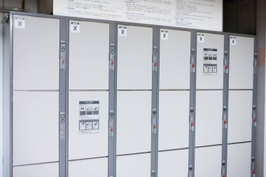 Üzerinde numaralandırılmış kapılar ve tabelalar olan beyaz dolaplar.