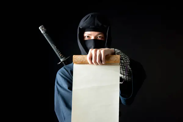 Person Ninja Costume Holding Paper — Stock Photo, Image