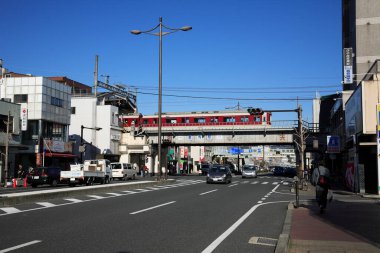 Gölgeler ve dokular, parlak Japon yolu boyunca mimarinin görüntüsüne derinlik katar..
