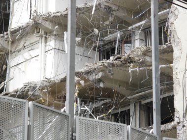 Kısmen çökmüş beton bina demirle enkazı gösteriyor.