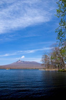 Güzel göl mavi gökyüzü ve bulutlar, arka planda manzaralı dağlar     