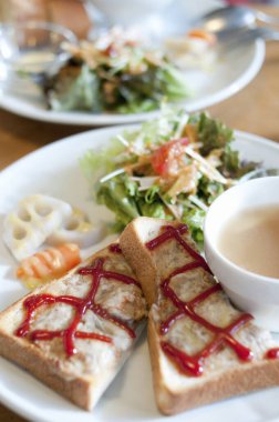 Taze salatanın yanında soslu kızarmış ekmek dilimleri.