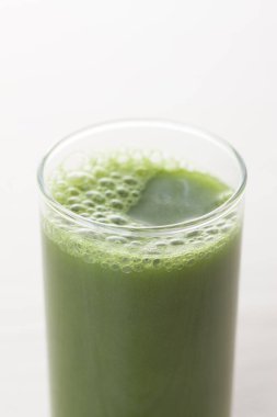 Açık arkaplanda yeşil, taze, sağlıklı organik içeceğin yakın plan görüntüsü.                                          