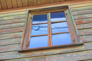 Kahverengi duvarında cam penceresi olan eski ahşap bina.