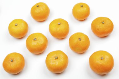 Beyaz arka planda yaprakları olan taze, sulu mandalinalar.