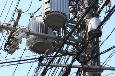 Elektrik transformatörlerini birbirine dolanmış elektrik kabloları arasında gösteren yakın plan
