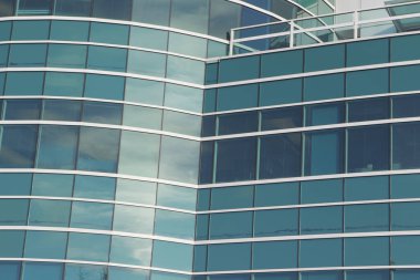 Cam duvarda yansıması olan cam bir bina.