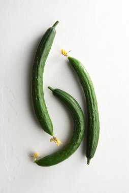 Beyaz arka planda üç taze salatalık, üst manzara. 