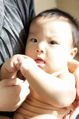 Annenin ellerinde mutlu Japon çocuk, ellerinde küçük oğlunu tutan kadın, yakın plan. 