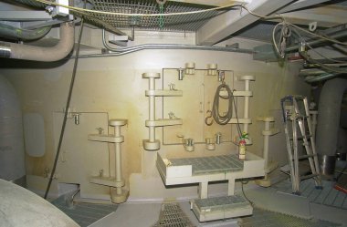 Boru basamakları, metal kapaklar ve kablolar içeren endüstriyel bodrum katı.