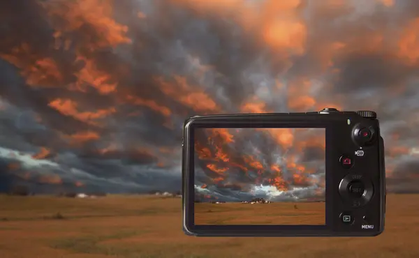 video camera with the sunset sky on the screen