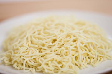 Masadaki beyaz kasede hazır erişteleri yakın..