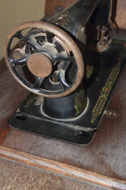 Kaliteli dikiş makinesi tahta masa yüzeyinde dinleniyor.