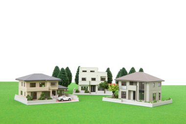 miniature houses models and green trees on grassy meadow.                                              