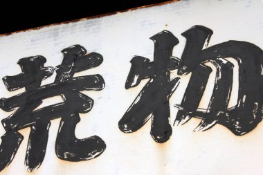 Yakından bakınca beyaz arka planda koyu siyah Japon kanji karakterlerini görüyoruz.