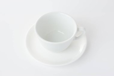 Beyaz arka planda fincan tabağı ile beyaz seramik fincan.