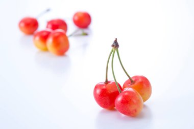 Beyaz arka planda kırmızı kiraz meyvesi