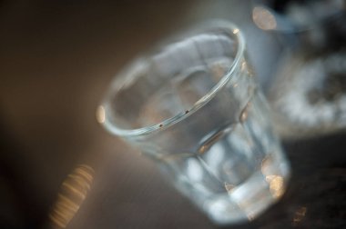 Koyu ahşap bir masanın üzerinde suyla dolu bir cam.