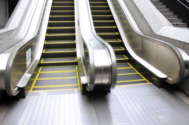 Arka plandaki metro istasyonunda yürüyen merdiven.