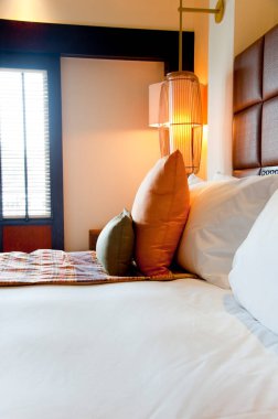 Yatağında rahat yastıklar olan bir otel odası.