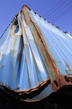 Paslı mavi metal nakliye konteynırı temiz gökyüzü arka planına karşı
