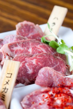 Mutfak masasında dilimlenmiş et tabağı, yakın görüş.