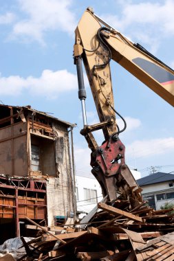 Ev inşaatının kaldırılması, endüstriyel binada çalışan kazıcı.                         